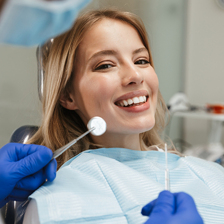 Woman smiling during her dental checkup and teeth cleaning in Portland