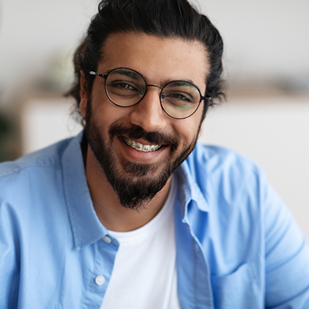 Adult man with braces smiling