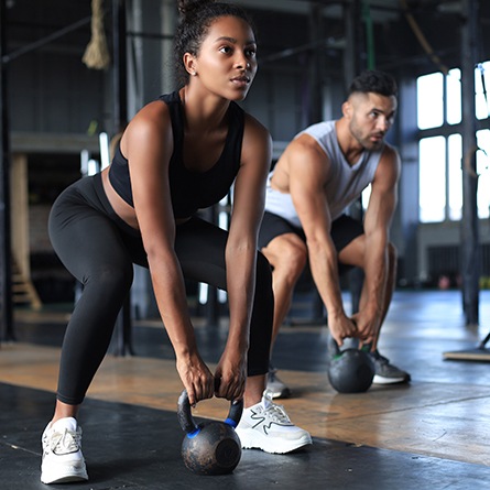 Couple lifting weights in workout class