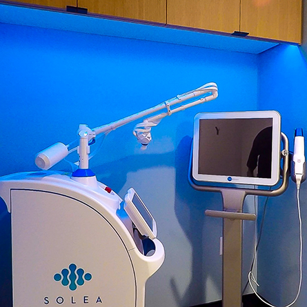 Solea dental laser machine standing against a blue wall in Portland dental office